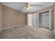 A bedroom features neutral walls, carpeted floor, ceiling fan, and a closet providing storage space at 11521 Se 1St Street Rd, Silver Springs, FL 34488