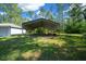 Large carport area surrounded by lush green landscaping on a beautiful sunny day at 11521 Se 1St Street Rd, Silver Springs, FL 34488