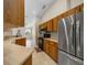 Functional kitchen featuring wood cabinets, stainless steel refrigerator, and modern appliances at 11521 Se 1St Street Rd, Silver Springs, FL 34488