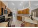 Functional kitchen featuring wood cabinets, tile flooring, and black appliances at 11521 Se 1St Street Rd, Silver Springs, FL 34488