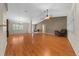 Bright living room with wood flooring, neutral paint, vaulted ceilings, and views of the kitchen at 11521 Se 1St Street Rd, Silver Springs, FL 34488