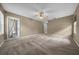 Large main bedroom featuring neutral carpet, a ceiling fan, and a door to the bathroom at 11521 Se 1St Street Rd, Silver Springs, FL 34488
