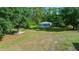 Overview of the property with covered picnic area, detached garage, equipment storage building, and open lawn at 11521 Se 1St Street Rd, Silver Springs, FL 34488