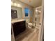 Modern bathroom featuring a glass shower, granite vanity, and wood-look floors at 12472 Se 67Th Terrace Rd, Belleview, FL 34420