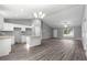 Spacious living room with open layout, kitchen island, gray walls, and modern flooring throughout the home at 12472 Se 67Th Terrace Rd, Belleview, FL 34420