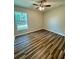 Bedroom with a ceiling fan, window, and attractive wood-look flooring at 13303 Sw 106Th Pl, Dunnellon, FL 34432