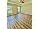 Bright bedroom with wood-look floors, ceiling fan, and well-lit windows, offering ample natural light at 13303 Sw 106Th Pl, Dunnellon, FL 34432