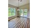Dining room features modern light fixture, large window with backyard view and wood-look flooring at 13303 Sw 106Th Pl, Dunnellon, FL 34432
