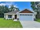 Charming single Gathering home featuring a two car garage, manicured lawn and stone veneer accents at 13303 Sw 106Th Pl, Dunnellon, FL 34432