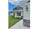 Home exterior showcasing manicured lawn, stone accents, and a covered entryway with stylish lighting at 13303 Sw 106Th Pl, Dunnellon, FL 34432