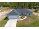 An aerial view shows the home with a driveway and front yard with trees in the background at 13561 Sw 85Th Pl, Dunnellon, FL 34432