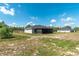 Wide backyard view of the home with a screened in patio, plenty of space, and other houses nearby at 13561 Sw 85Th Pl, Dunnellon, FL 34432