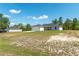 Spacious yard surrounding a home with a two-car garage, set against a bright blue sky at 13561 Sw 85Th Pl, Dunnellon, FL 34432
