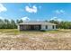 Rear exterior view of the home showing a screened patio and yard with a wooden fence nearby at 13561 Sw 85Th Pl, Dunnellon, FL 34432