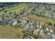 Aerial view of homes on a street with a golf course and a nearby wooded area at 1377 Sw 161St Pl, Ocala, FL 34473