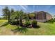 Exterior view of the home showing the manicured lawn, screened lanai, and lush landscaping at 1377 Sw 161St Pl, Ocala, FL 34473