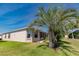 The home's backyard features a lush lawn, palm trees, and a screened lanai at 1377 Sw 161St Pl, Ocala, FL 34473