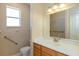 A simple bathroom features a toilet, sink, vanity and a large mirror at 1377 Sw 161St Pl, Ocala, FL 34473