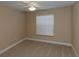A simple bedroom features carpet, a ceiling fan, and a large window at 1377 Sw 161St Pl, Ocala, FL 34473