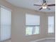 Bright bedroom featuring three windows, a ceiling fan, and neutral-toned walls at 1377 Sw 161St Pl, Ocala, FL 34473