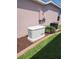 Exterior home view with a Generac generator, AC unit, and landscaping against a pink exterior wall at 1377 Sw 161St Pl, Ocala, FL 34473