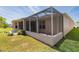 View of the home's exterior with a screened lanai and well-maintained lawn at 1377 Sw 161St Pl, Ocala, FL 34473