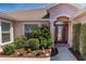 Close-up of the front door surrounded by lush landscaping and a manicured garden at 1377 Sw 161St Pl, Ocala, FL 34473