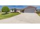 An inviting home features a wide driveway, manicured lawn, neatly trimmed shrubbery, and a tidy garden at 1377 Sw 161St Pl, Ocala, FL 34473