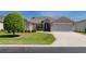 An inviting home has a two-car garage, attractive front door, neatly trimmed shrubbery, and tidy lawn at 1377 Sw 161St Pl, Ocala, FL 34473