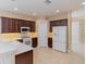 Kitchen showcasing dark wood cabinets, modern white appliances, and ample counter space at 1377 Sw 161St Pl, Ocala, FL 34473