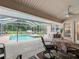 Covered patio with seating area overlooking the screened-in pool and hot tub at 16 Count Fleet Dr, Ocala, FL 34482