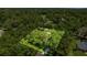 Aerial view of property with a green lawn and surrounding lush trees at 1675 Se 73Rd Pl, Ocala, FL 34480