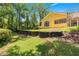 Backyard view showing lush landscape and retaining wall feature at 1675 Se 73Rd Pl, Ocala, FL 34480