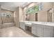 Bright bathroom with dual sinks, garden tub, custom cabinets, and large windows bringing in plenty of natural light at 1675 Se 73Rd Pl, Ocala, FL 34480