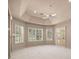 This bright bedroom features multiple windows, custom shutters, neutral paint, and a ceiling fan for added comfort at 1675 Se 73Rd Pl, Ocala, FL 34480