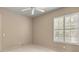 Bright bedroom featuring neutral walls, plush carpet, plantation shutters, and a ceiling fan at 1675 Se 73Rd Pl, Ocala, FL 34480