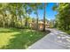 Exterior of a home featuring a green lawn, mature trees, and a circular driveway at 1675 Se 73Rd Pl, Ocala, FL 34480