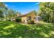 Exterior view of the home showcasing lush landscaping and a screened enclosure at 1675 Se 73Rd Pl, Ocala, FL 34480