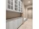 Hallway with white cabinets with glass door fronts, granite countertops, and tiled floors at 1675 Se 73Rd Pl, Ocala, FL 34480