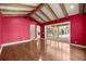 Open living room with exposed beams, wood flooring, and sliding doors to outdoor living space at 1675 Se 73Rd Pl, Ocala, FL 34480