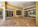 Outdoor patio features large windows, view of screened-in pool and octagonal stone floors at 1675 Se 73Rd Pl, Ocala, FL 34480