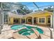 Backyard pool with hot tub and screened-in lanai, with beige stone tile at 1675 Se 73Rd Pl, Ocala, FL 34480