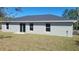 Grey home exterior featuring an ample backyard perfect for entertaining at 21301 Sw Rainbow Lakes Blvd, Dunnellon, FL 34431