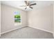 Cozy bedroom with a ceiling fan and a large window overlooking the outdoors, neutral paint at 21301 Sw Rainbow Lakes Blvd, Dunnellon, FL 34431