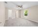 Spacious bedroom with soft carpeting, ceiling fan, and ample natural light from a large window at 21301 Sw Rainbow Lakes Blvd, Dunnellon, FL 34431