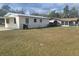 Spacious backyard with lush grass, featuring a carport, offering ample room for outdoor activities and relaxation at 2215 Ne 16Th Ct, Ocala, FL 34470