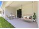A covered lanai features a table, chairs and a porch swing with stylish pillows at 2254 Amberly Ave, Orlando, FL 32833