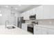 A modern kitchen with stainless steel appliances, white cabinets, and quartz countertops at 2254 Amberly Ave, Orlando, FL 32833