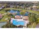 Aerial view of community pool and clubhouse overlooking a large pond with fountain and mature trees at 2417 Se 23Rd St, Ocala, FL 34471