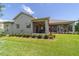 Backyard with a covered patio and screened in porch, surrounded by green lawn and landscaping at 2417 Se 23Rd St, Ocala, FL 34471